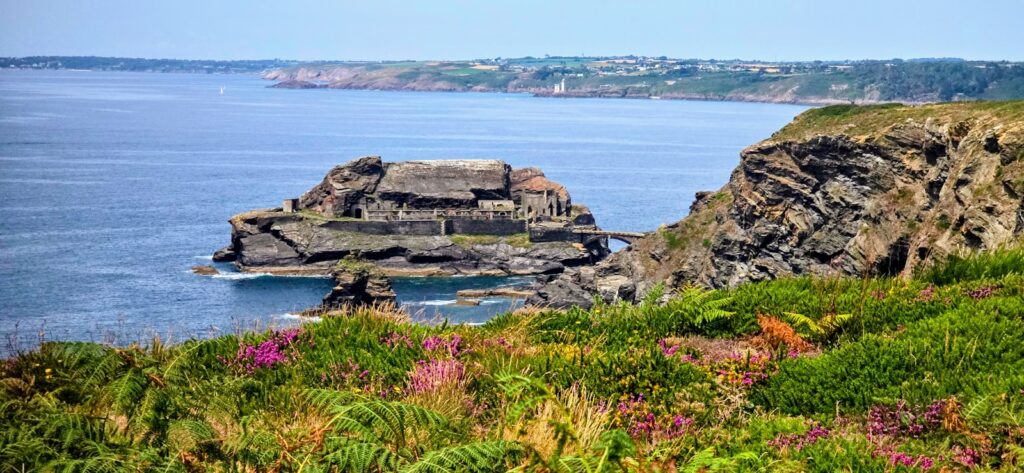 A large body of water sitting next to a lush green hillside