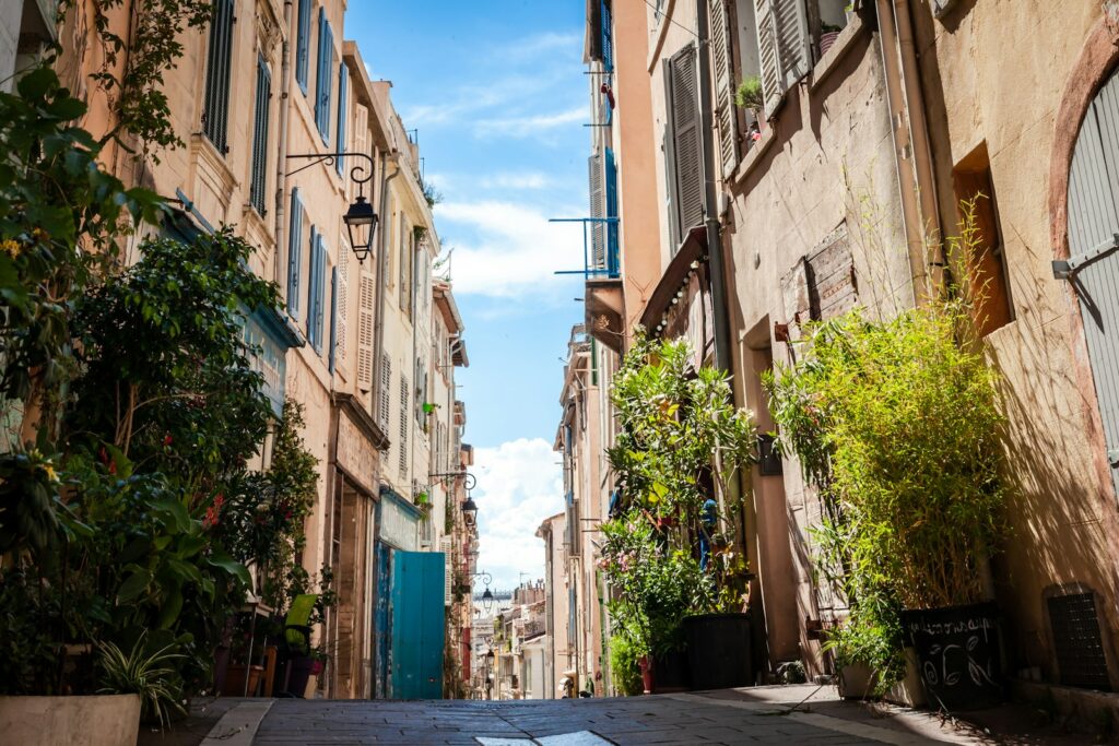 cars parked on sidewalk in between buildings during daytime