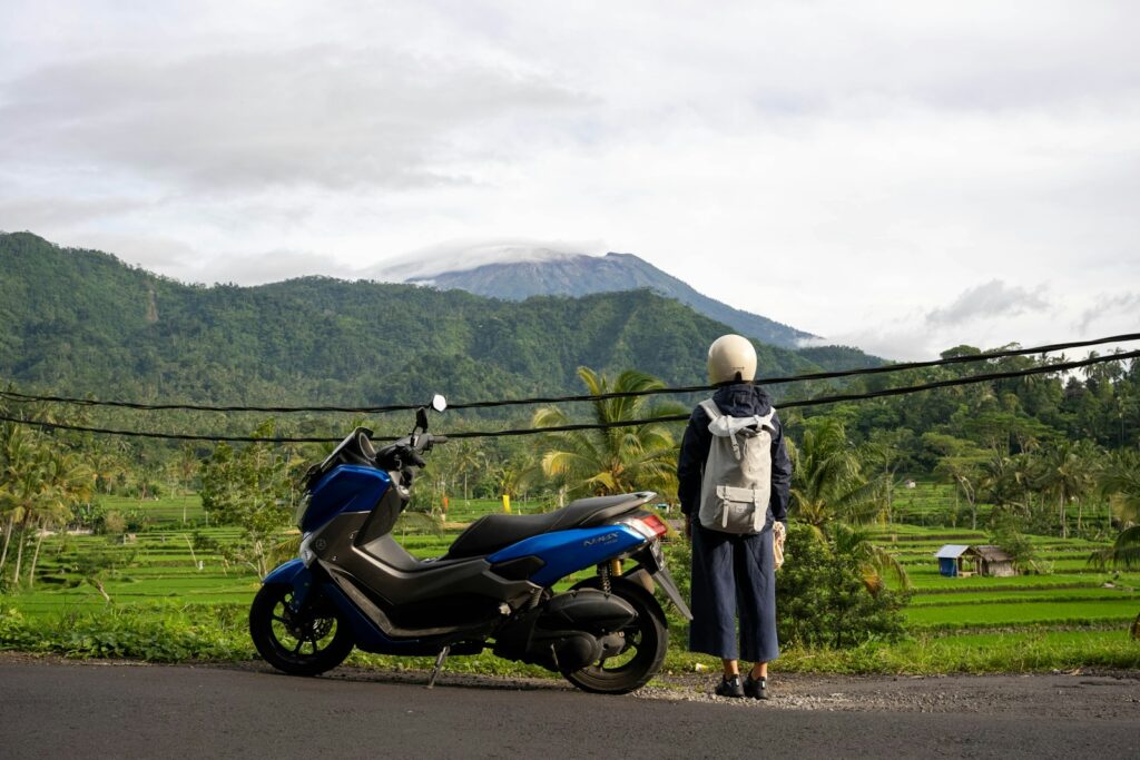 a person standing next to a motorcycle on a road