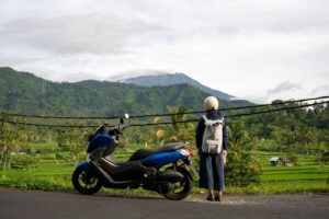 a person standing next to a motorcycle on a road